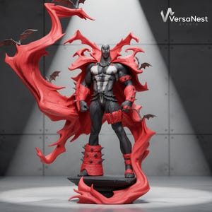 May include: A detailed figurine of a muscular character with a black textured suit, white chest emblem, and a large, flowing red cape. The figure features red spiked gauntlets and leg guards, standing on a base with small bat figures. VersaNest Studio logo.