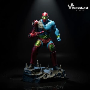 May include: A detailed action figure of a character with blue skin, green face, and red helmet and armor. The figure stands on a rocky base and has a mechanical arm. The figure is from VersaNest Studio.