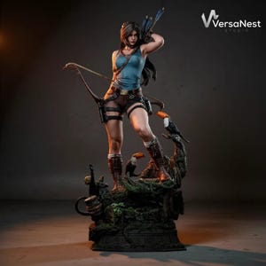 May include: A detailed statue of a woman in a blue tank top and brown shorts, holding a bow and arrow. She is standing on a detailed base with a toucan. The statue is a collectible item.