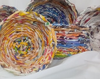 Könnte beinhalten: Ein Set aus bunten geflochtenen Körben aus recyceltem Papier. Die Körbe sind rund und haben ein Spiralmuster. Sie sind eine großartige Möglichkeit, Ihrem Zuhause einen Hauch von Farbe und Stil zu verleihen.