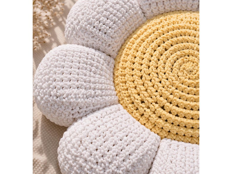 May include: A handmade crochet daisy pillow with a yellow center and white petals. The pillow is round and has a textured appearance, with the crochet stitches clearly visible. The daisy design is a charming addition to any room.