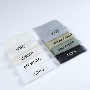 May include: A collection of fabric swatches in various colors, including ivory, cream, off-white, white, gray, olive green, sea green, and black. Each swatch has a label with its color name. The fabrics appear to be lightweight and textured.