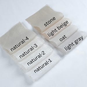 May include: A collection of fabric swatches in various neutral colors, including stone, light beige, oat, and light gray. Each swatch is labeled with its color name and a "natural" series number, showcasing the range of tones.