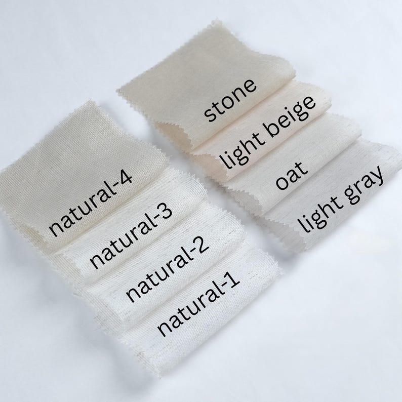 May include: A collection of fabric swatches in various neutral colors, including stone, light beige, oat, and light gray. Each swatch is labeled with its color name and a "natural" series number, showcasing the range of tones.