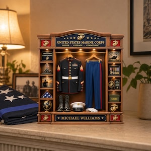 May include: A wooden display case featuring a United States Marine Corps uniform, including a dress blue jacket, trousers, boots, and a white cap. The unit includes internal lighting, miniature medals, a globe, and the name Michael Williams.