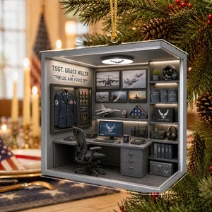 May include: A rectangular, box-style Christmas ornament featuring a miniature U.S. Air Force office scene. The interior displays a desk, a black office chair, a computer monitor with the Air Force logo, a framed uniform, and shelves with military decor.