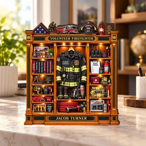 May include: A miniature wooden display shelf titled VOLUNTEER FIREFIGHTER and JACOB TURNER, featuring a central firefighter jacket, boots, and helmet. The shelves contain miniature books, a fire truck, radio, fire extinguisher, and gear.