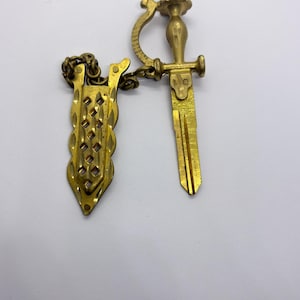 Llavero Kwikset con forma de espada de latón macizo, collar con colgante de cabeza de león, llave virgen de repuesto para el hogar.