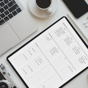 May include: An overhead shot of a workspace featuring a laptop, tablet, camera, phone, and coffee cup. The tablet displays a daily planner with sections for tasks and schedules. A stylus and wireless earbuds are also present.