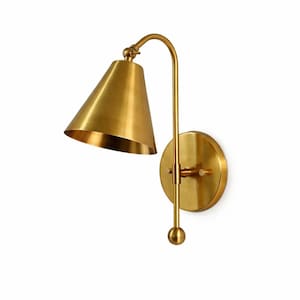 May include: A brass wall sconce with a conical shade and a curved arm. The sconce has a round backplate and a small ball at the bottom. The fixture is made of a shiny, gold-colored metal.