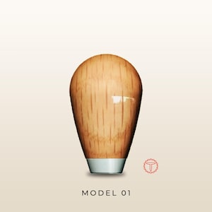 May include: A light brown wooden gear shift knob with a smooth, polished finish and a vertical grain pattern. The knob features a tapered, rounded top and a silver-colored metal base. The text "MODEL 01" is printed below the object in black.