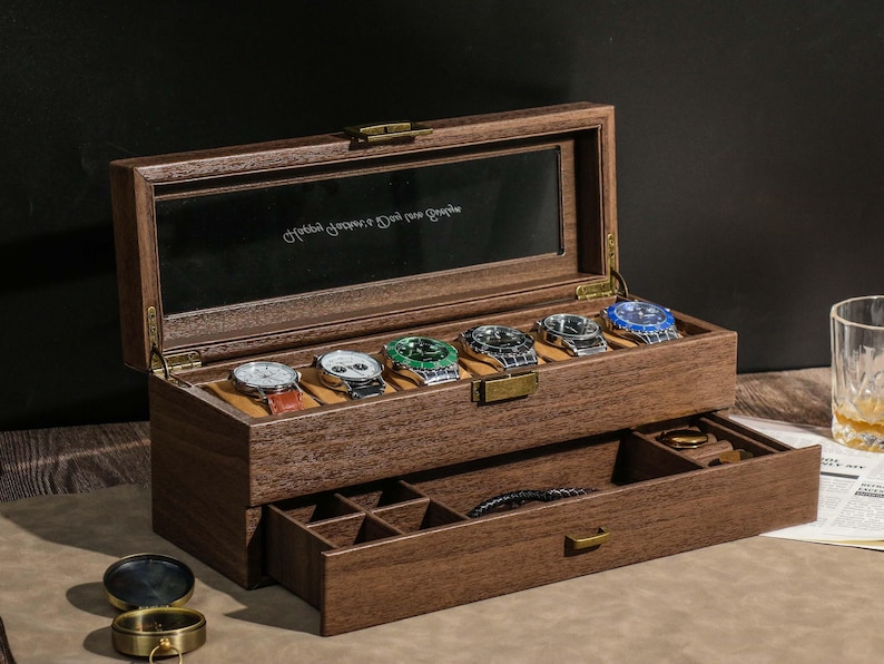 May include: A wooden watch box with a hinged lid and a pull-out drawer. The box is open, revealing six watches with various colored faces. The drawer contains a bracelet and compartments for other accessories. The box has a mirrored interior.