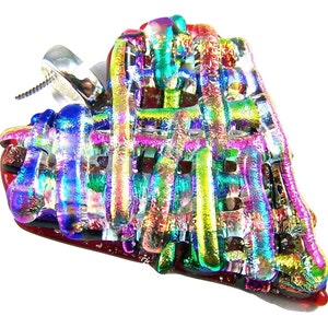 May include: A dichroic glass pendant with a silver bail. The pendant features a woven design with vibrant colors including blue, green, red, and yellow. The pendant has a unique, textured appearance and is set against a white background.