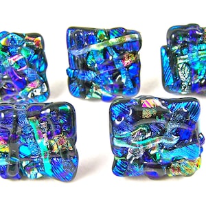 May include: Five square-shaped glass tiles with a blue, black and iridescent finish. The tiles have a textured, mosaic-like appearance.