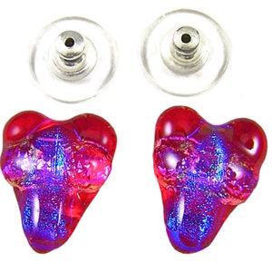 May include: A pair of heart-shaped stud earrings. The earrings are a vibrant red with iridescent purple and blue accents. The earring posts are silver-colored metal with clear plastic backs. The earrings are set against a white background.