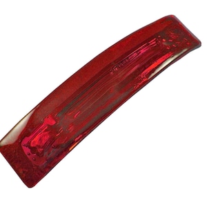 May include: A red plastic hair clip with a shiny, iridescent finish.