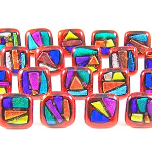 May include: A selection of square glass beads with a red border and abstract designs. Each bead has a unique arrangement of geometric shapes in blue, yellow, purple, and green. The beads are displayed on a white background.