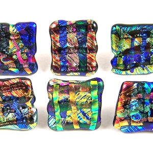 May include: Six square-shaped glass tiles with a colorful, iridescent, and abstract design. The tiles are made of dichroic glass and feature a variety of colors, including blue, green, gold, and red.