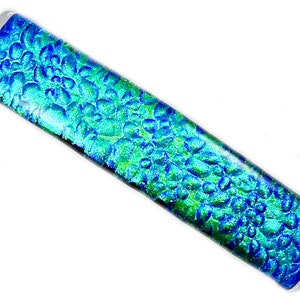 May include: A rectangular glass piece with a textured, bubble-like pattern. The colors transition from blue to green, creating an iridescent effect. The glass has a clear, glossy finish.