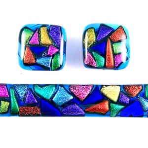Peut inclure: Ensemble de bijoux en verre dichroïque aux tons de bleu, or, violet, vert et rouge. L'ensemble comprend deux boucles d'oreilles carrées et une barrette rectangulaire, toutes avec un motif en mosaïque.