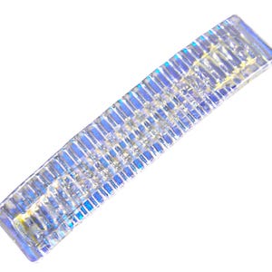 May include: A silver iridescent hair clip with a textured design.