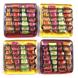 May include: Four square glass tiles featuring a woven pattern in shades of red, orange, yellow, and green. The tiles have a metallic sheen and are ideal for adding a touch of colour and texture to any project.