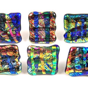 May include: Six dichroic glass square beads with a textured, irregular surface. The beads feature a vibrant mix of colors including blue, green, yellow, and red, creating a mosaic-like appearance. Each bead is approximately 0.75 inches square.
