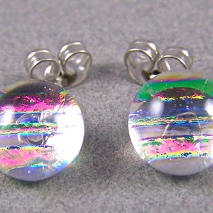 May include: A pair of iridescent glass earrings with silver posts. The glass is clear with a rainbow effect and has a striped pattern.