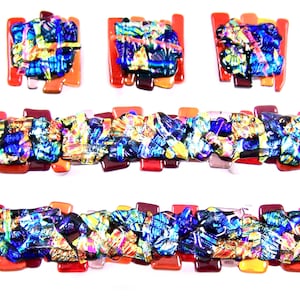 May include: A set of colorful glass mosaic tiles in shades of red, orange, yellow, blue, and purple. The tiles are arranged in a geometric pattern and have a shiny, iridescent finish.