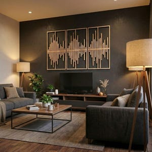 Op de afbeelding: Een moderne woonkamer met een donkergrijze bank, een houten salontafel en een groot houten kunstwerk aan de muur. De kamer wordt verlicht door vloerlampen met beige tinten, wat een warme sfeer creëert. Een televisie is aan de muur bevestigd.