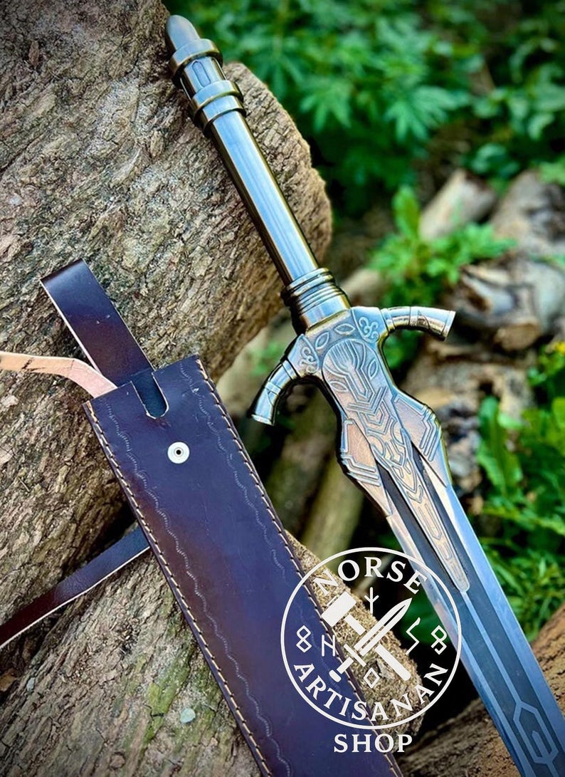 May include: A detailed image of a sword with a silver blade and handle, resting against a tree trunk. The sword has intricate designs on the hilt and a leather sheath. The image also includes the text "NORSE ARTISAN SHOP" in a circular logo.