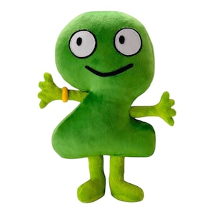 May include: A plush green number two character with large white eyes, a black smile, and small arms and legs. It has a yellow ring on one arm. The toy is soft and cuddly, perfect for children.