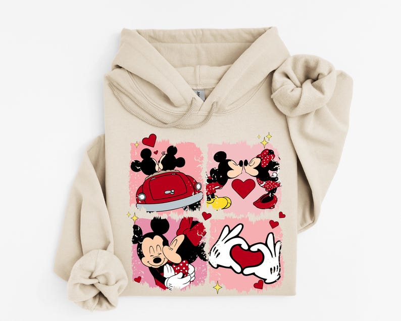 May include: Beige hoodie with a four-panel design showcasing Mickey and Minnie Mouse illustrations. The panels depict romantic scenes with hearts and a red car. The design includes yellow stars and a pink background.