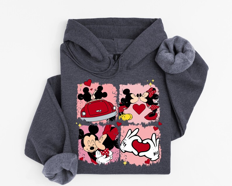 May include: Dark grey hooded sweatshirt with a graphic of Mickey and Minnie Mouse in romantic poses. The design includes hearts, a red car, and the characters kissing. The sweatshirt is made of a soft material.