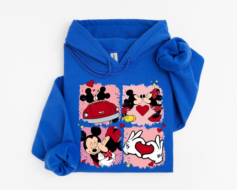 May include: A royal blue hooded sweatshirt with a graphic of Mickey and Minnie Mouse in romantic poses. The design includes a red car, hearts, and the characters kissing. The sweatshirt is made of a soft material.