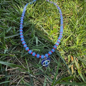 Collar de cuentas con dije de mal de ojo