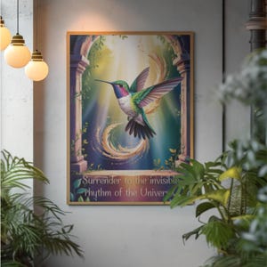 Puede incluir: Un cuadro enmarcado con un colibrí vibrante con plumas verdes, azules y rojas en vuelo. La obra de arte incluye el texto "Surrender to the invisible rhythm of the Universe."