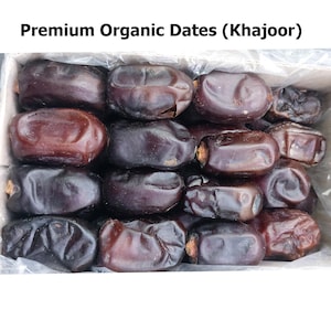 Puede incluir: Una caja llena de dátiles orgánicos premium, también conocidos como Khajoor. Los dátiles son de color marrón oscuro, con una textura ligeramente arrugada. El texto "Premium Organic Dates (Khajoor)" se muestra en la parte superior de la imagen.
