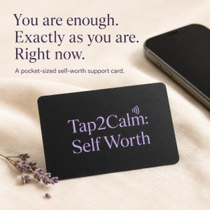 Può includere: Una carta rettangolare nera con il testo viola Tap2Calm: Self Worth e un'icona di segnale. Sopra, il testo recita: You are enough. Exactly as you are. Right now. A pocket-sized self-worth support card. È visibile un piccolo rametto di lavanda essiccata.