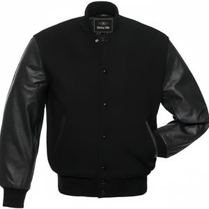 May include: A black varsity jacket with black leather sleeves. The jacket has a ribbed collar, cuffs, and hem. The front features a button-up closure and two pockets. The label on the jacket reads "Victory Side".