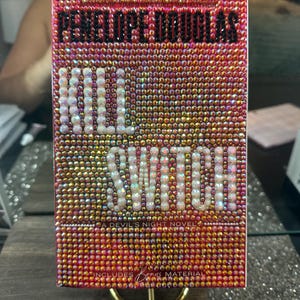 Pu&ograve; includere: Una copertina di libro rettangolare ricoperta di piccole, scintillanti, strass iridescenti. Il titolo "KILL SWITCH" &egrave; in grandi lettere bianche. Il nome dell'autore, "PENELOPE DOUGLAS", &egrave; in alto in lettere nere.