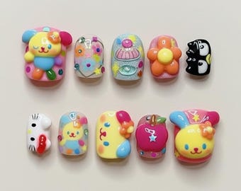 Puede incluir: Diez diseños de uñas decorativas y coloridas. Los diseños incluyen un oso, una flor, un pingüino y otros personajes lindos. Las uñas están pintadas en varios colores, incluyendo rosa, amarillo, azul y blanco.