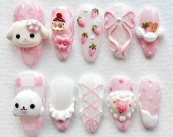 May include: A set of ten artificial nails in various designs. The nails feature a light pink color scheme with 3D embellishments, including a puppy, a seal, strawberries, bows, and a cupcake. Some nails have a marble effect or a checkered pattern.
