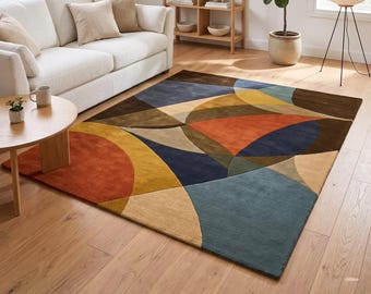 Könnte beinhalten: Ein rechteckiger Teppich mit einem geometrischen Muster aus überlappenden Kreisen und Bögen in den Farben gebranntes Orange, Senfgelb, Marineblau, Dunkelbraun und Beige. Der Teppich hat eine kurzflorige Textur und liegt auf einem hellen Holzboden.