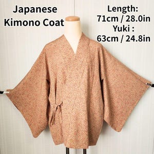 May include: A Japanese Kimono Coat in a light brown floral pattern. The coat has a V-neck and wide sleeves. The length is 28.0 inches (71cm), and the Yuki is 24.8 inches (63cm). The coat is tied at the waist.