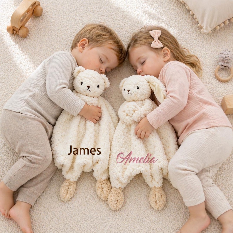 May include: Two children sleeping, each cuddling a cream-colored plush security blanket. One is a bear, the other a bunny. The bear blanket has the name "James" embroidered on it, and the bunny blanket has the name "Amelia".