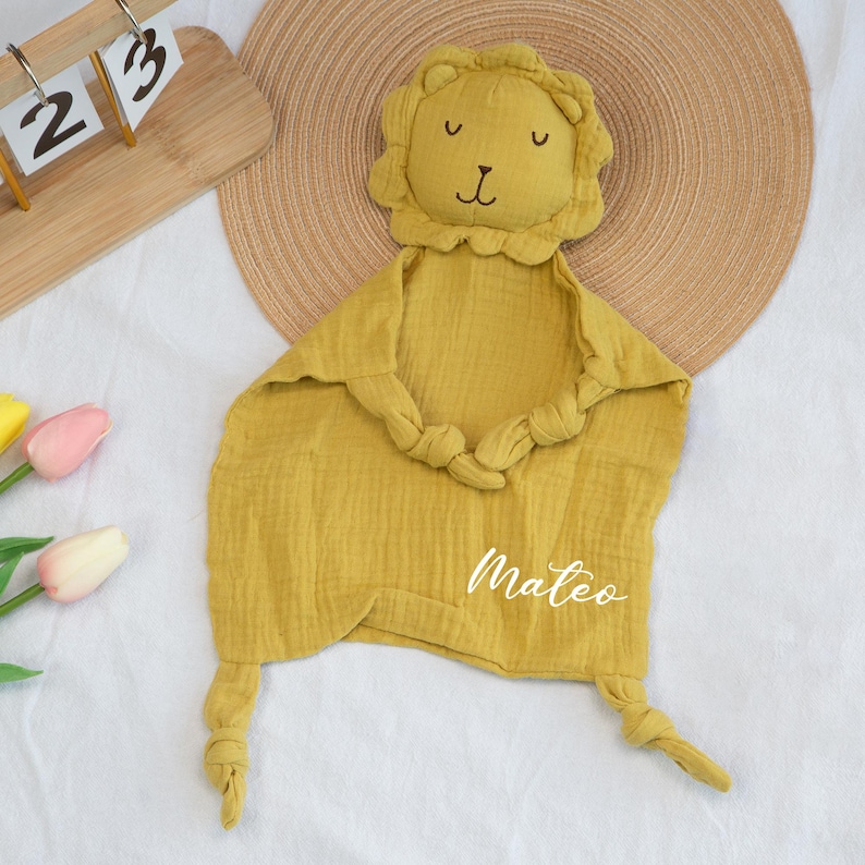 Pu&ograve; includere: Coperta di sicurezza per bambini giallo senape con testa di leone e dettagli annodati. La coperta ha il nome "Mateo" ricamato in bianco. Il viso del leone ha occhi e naso ricamati. La coperta &egrave; realizzata in tessuto morbido e strutturato.