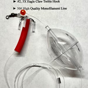 May include: A fishing bubble straw rig featuring a 2.5 inch clear plastic bubble, a red latex rubber tubing straw, a #2 3X Eagle Claw treble hook, and 50# monofilament line. The text BUBBLE STRAW RIG and component details are printed above the rig.