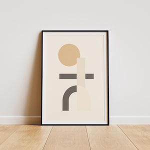 Op de afbeelding: Abstracte kunstprint in een zwarte lijst. Het kunstwerk toont geometrische vormen in beige, grijs en bruin tegen een crèmekleurige achtergrond. Een beige cirkel, grijze horizontale lijn en gebogen vorm zijn zichtbaar.