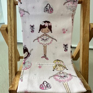 Puede incluir: Una peque&ntilde;a silla de madera con un asiento de tela rosa con un patr&oacute;n de bailarinas, flores y bolsas de ballet. La silla es perfecta para una casa de mu&ntilde;ecas o una sala de juegos.